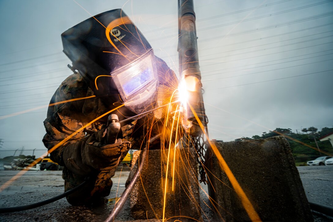 A U.S. Marine welds a fence on Camp Foster, Japan, Dec. 4.