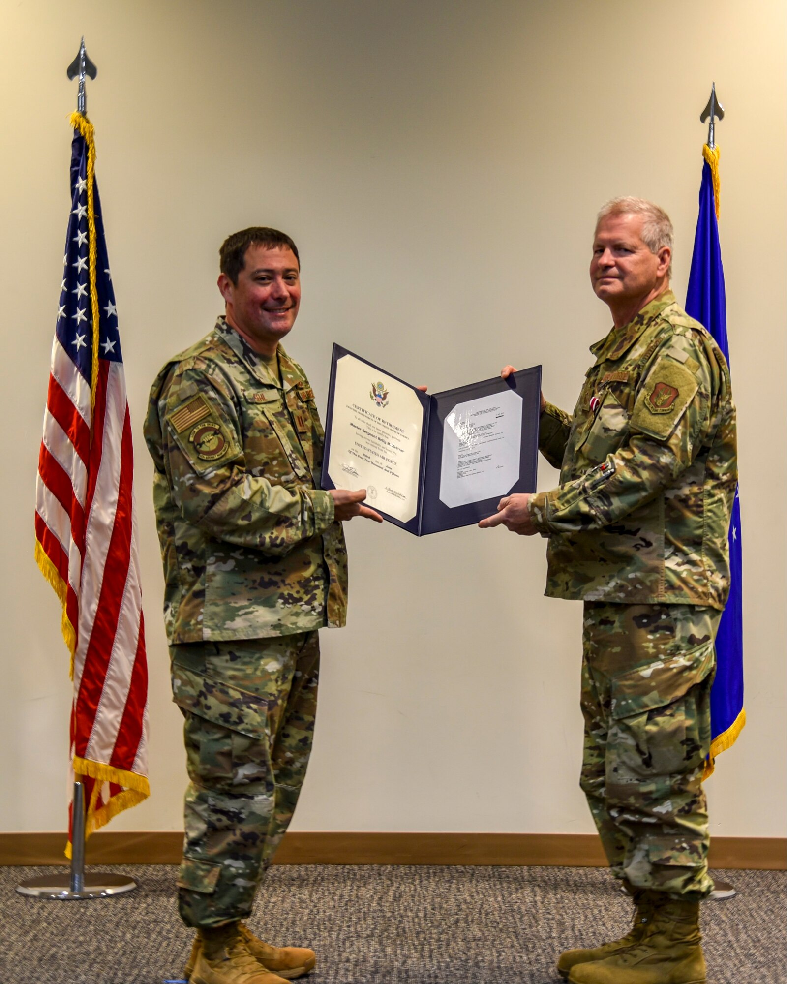 Capt. Anthony Gehl of the 403rd Aircraft Maintenance Squadron, presents Master Sgt. James Rials with his certificate of retirement at the Roberts Consolidated Maintenance Facility Dec. 6, 2020. Rials retired after serving nearly 40 years, all with the Air Force Reserve's 403rd Wing at Keesler Air Force Base. (U.S. Air Force photo by Tech. Sgt. Lacey Matthews)