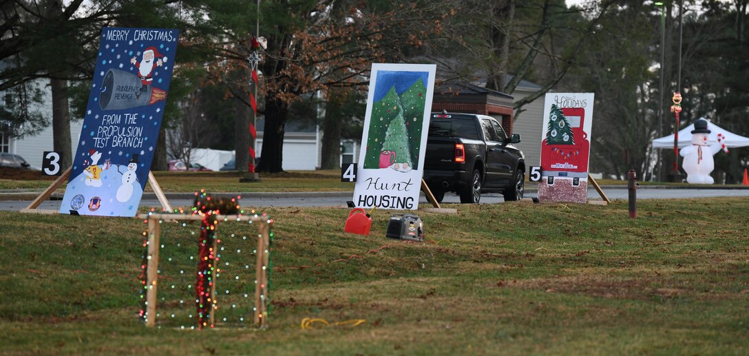 A truck passes by oversized greeting cards, Dec. 12, 2020, while attending the Children's Candy Cane Caravan at Arnold Air Force Base, Tenn. The greeting cards were made by Arnold Engineering Development Complex units. Attendees of the event voted for their favorite. (U.S. Air Force photo by Jill Pickett)