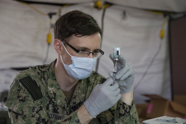 Seaman Dillon Botwell, a hospital corpsman with U.S. Naval Hospital Okinawa, prepares the Moderna COVID-19 vaccine to be administered to U.S. Marine Corps and Navy medical personnel and first responders at the U.S. Naval Hospital Okinawa on Camp Foster, Okinawa, Japan, Dec. 29, 2020.