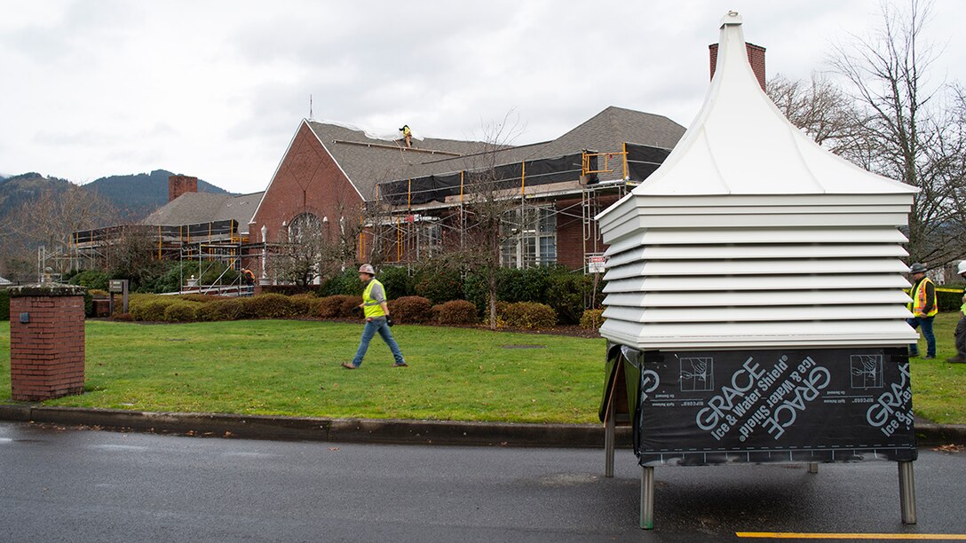 Workers place the new Auditorium building cupola within reach of the crane that will lift it into place.