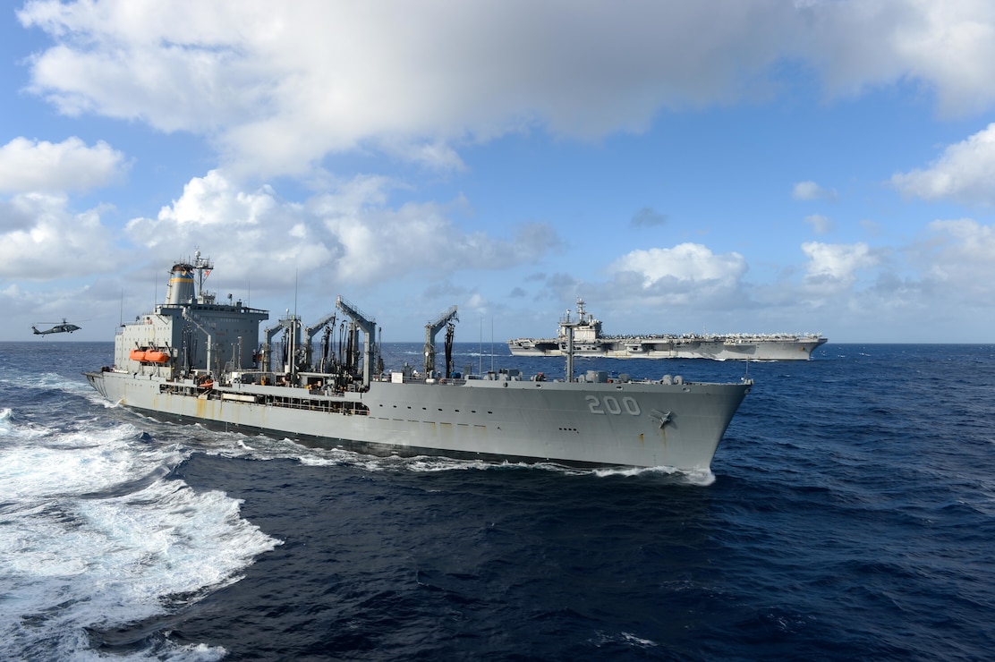 The aircraft carrier USS Theodore Roosevelt (CVN 71), back, transits alongside the Military Sealift Command fleet replenishment oiler USNS Guadalupe (T-AO 200) Jan. 1, 2021.