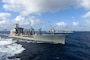 The aircraft carrier USS Theodore Roosevelt (CVN 71), back, transits alongside the Military Sealift Command fleet replenishment oiler USNS Guadalupe (T-AO 200) Jan. 1, 2021.