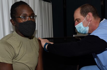 Staff Sgt. Yolande Allen receives a dose of COVID-19 vaccine from Douglas Sutton during a vaccine rollout at Camp Johnson, Vermont, Jan. 4, 2021. The Vermont National Guard received 200 doses of the Moderna vaccine in late December. Allen is a performer with the 40th Army Band who specializes in flute, tenor saxophone, and vocals. Sutton is a registered nurse with the University of Vermont Medical Center.