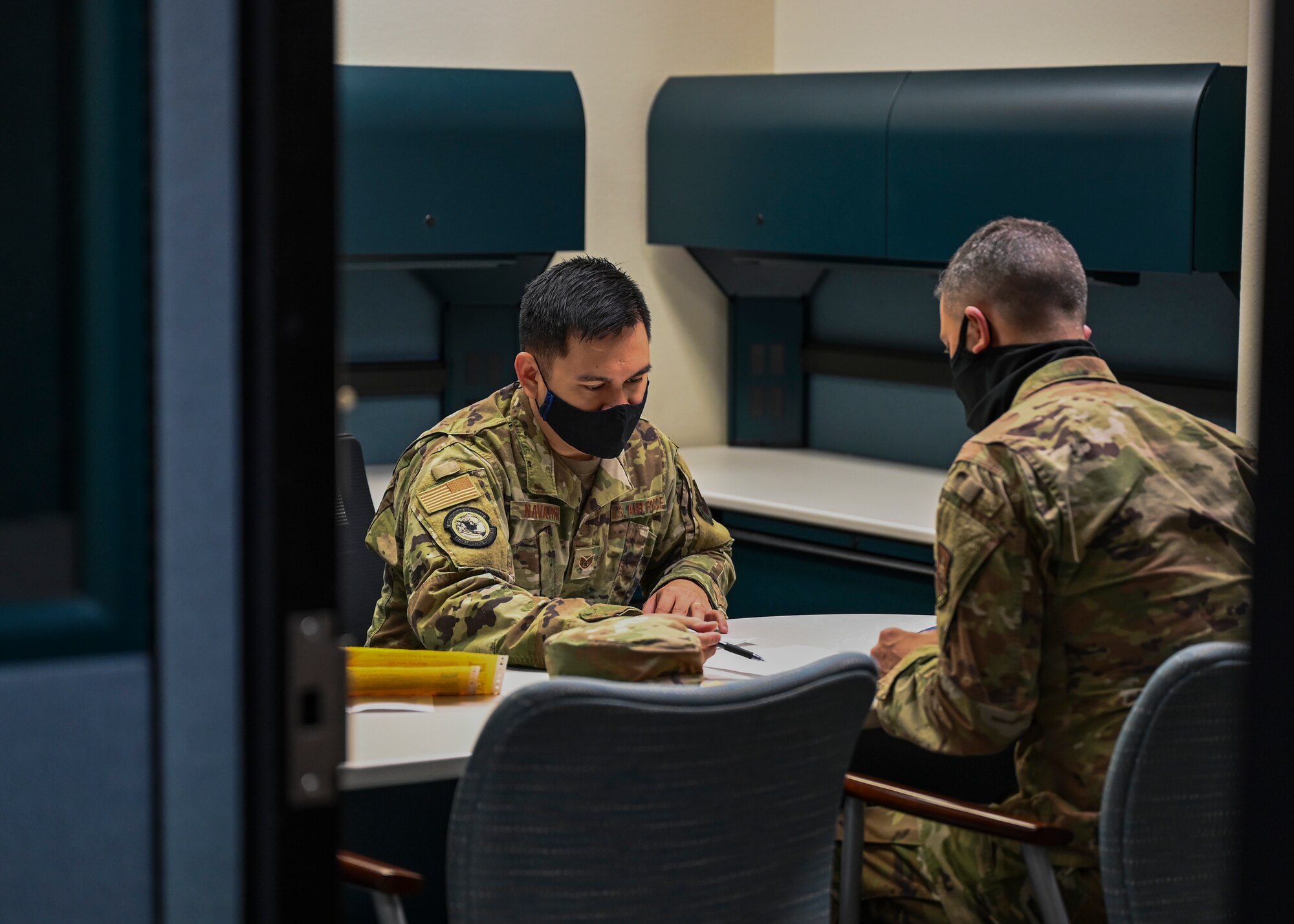2 uniformed members sit together to do paperwork