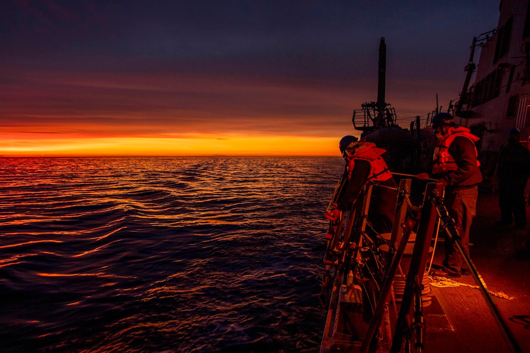 A ship transits the Pacific Ocean at sunset.