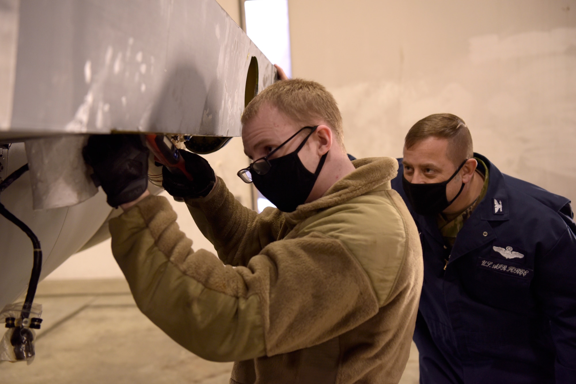 U.S. Air Force Col. Jesse J. Friedel, right, the 35th Fighter Wing commander observes Senior Airman Evan Wilcox, right, a 35th Aircraft Maintenance Squadron assistant dedicated crew chief, using a wrench on a horizontal stabilizer actuator on an F-16 Fighting Falcon during a Wild Weasel Walk-Through at Misawa Air Base, Japan, Dec. 29, 2020. Friedel learned about what it takes to put a stabilizer in an F-16 Fighting Falcon to get the aircraft up and flying again. (U.S. Air Force photo by Airman 1st Class Joao Marcus Costa)