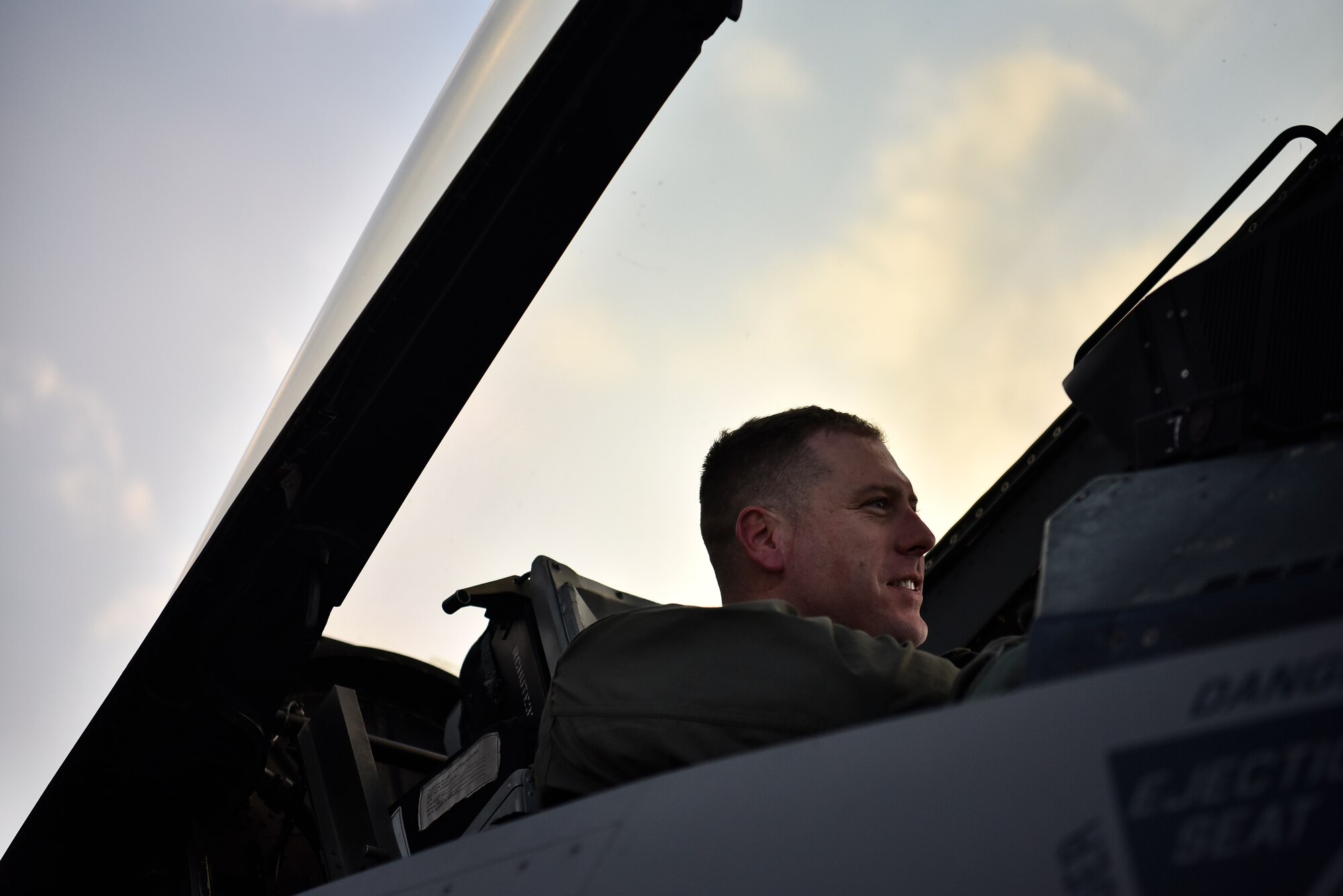 An Airman sits in an F-16 cockpit.