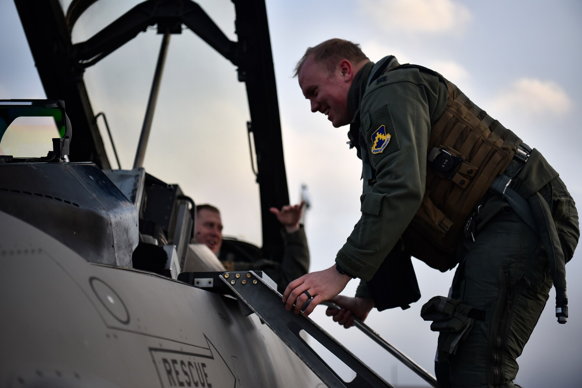 A pilot climbs out of an F-16.