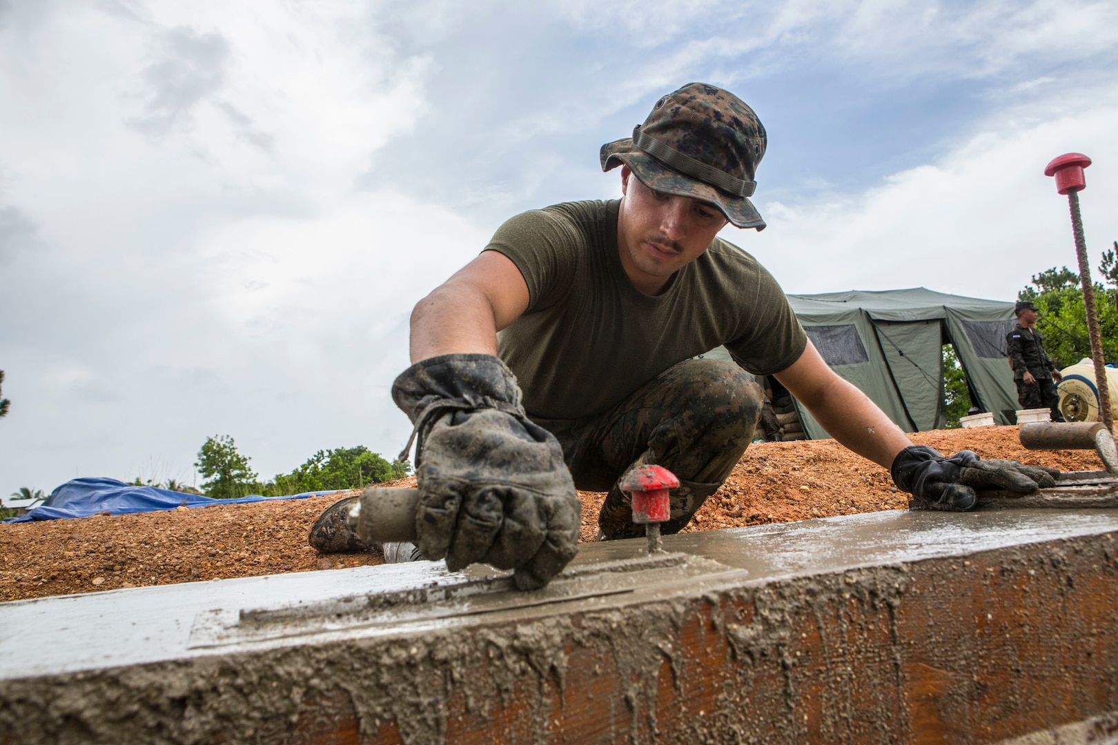 A U.S. Marine uses a float to even out the surface of cement for the foundation of the Republica de Cuba School in Puerto Lempira, Honduras, Aug. 14.