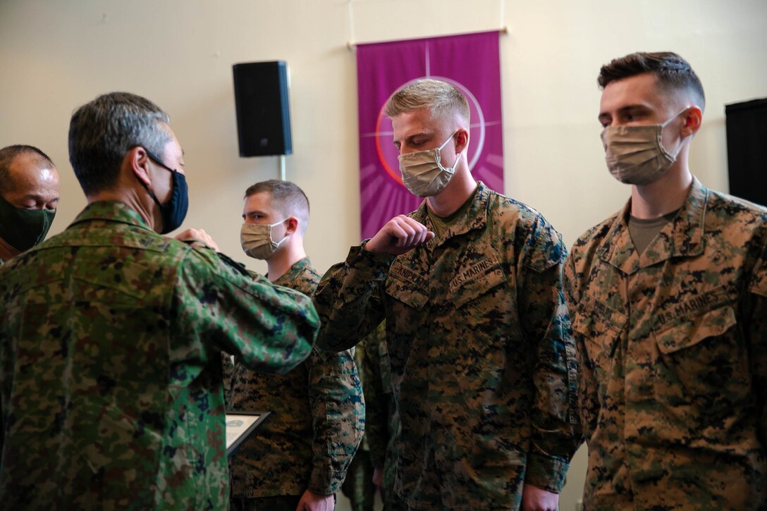 U.S. Marine Corps Brig. Gen. Kyle B. Ellison, commanding general of 3D Marine Expeditionary Brigade, and Maj. Gen. Takanori Hirata recognize service members involved in Exercise Yama Sakura 79 during the closing ceremony on Camp Courtney, Okinawa, Japan, Dec. 14, 2020.