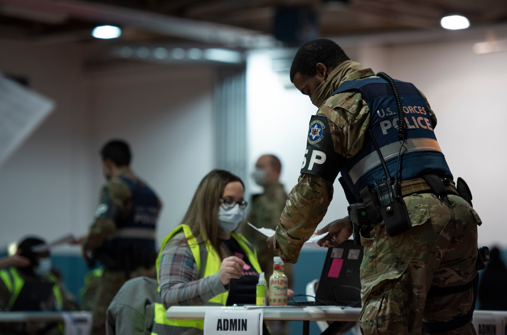 A 569th U.S. Forces Police Squadron first responder hands a document to an administrator at a vaccine clinic on Ramstein Air Base, Germany, Jan. 4, 2021.