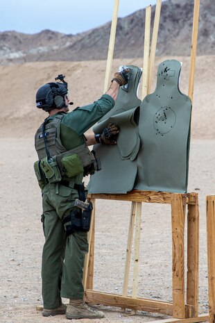 U.S. Marine Corps Cpl. Eddie Moran, assistant team commander, Special Reaction Team, Provost Marshall’s Office, Marine Air Ground Task Force Training Command, staples a silhouette target during an SRT familiarization range at Marine Corps Air Ground Combat Center, Twentynine Palms, California, Dec. 11, 2020. SRT Marines are military police officers trained in hostage situation, active shooter and barricaded suspect response. (U.S. Marine Corps photo by Lance Cpl. Joshua Sechser)