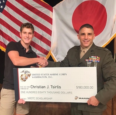 Lt. Col. Christopher Tsirlis presents his son, Christian, with the $180,000 Naval Reserve Officer Training Corps scholarship during his high school awards night in 2019. Christian earned the scholarship in 2019 after a rigorous and competitive application process. He proved he was worthy of the scholarship through his academic achievements and proven leadership abilities as the captain of his school football and track teams. He also demonstrated outstanding physical fitness abilities.