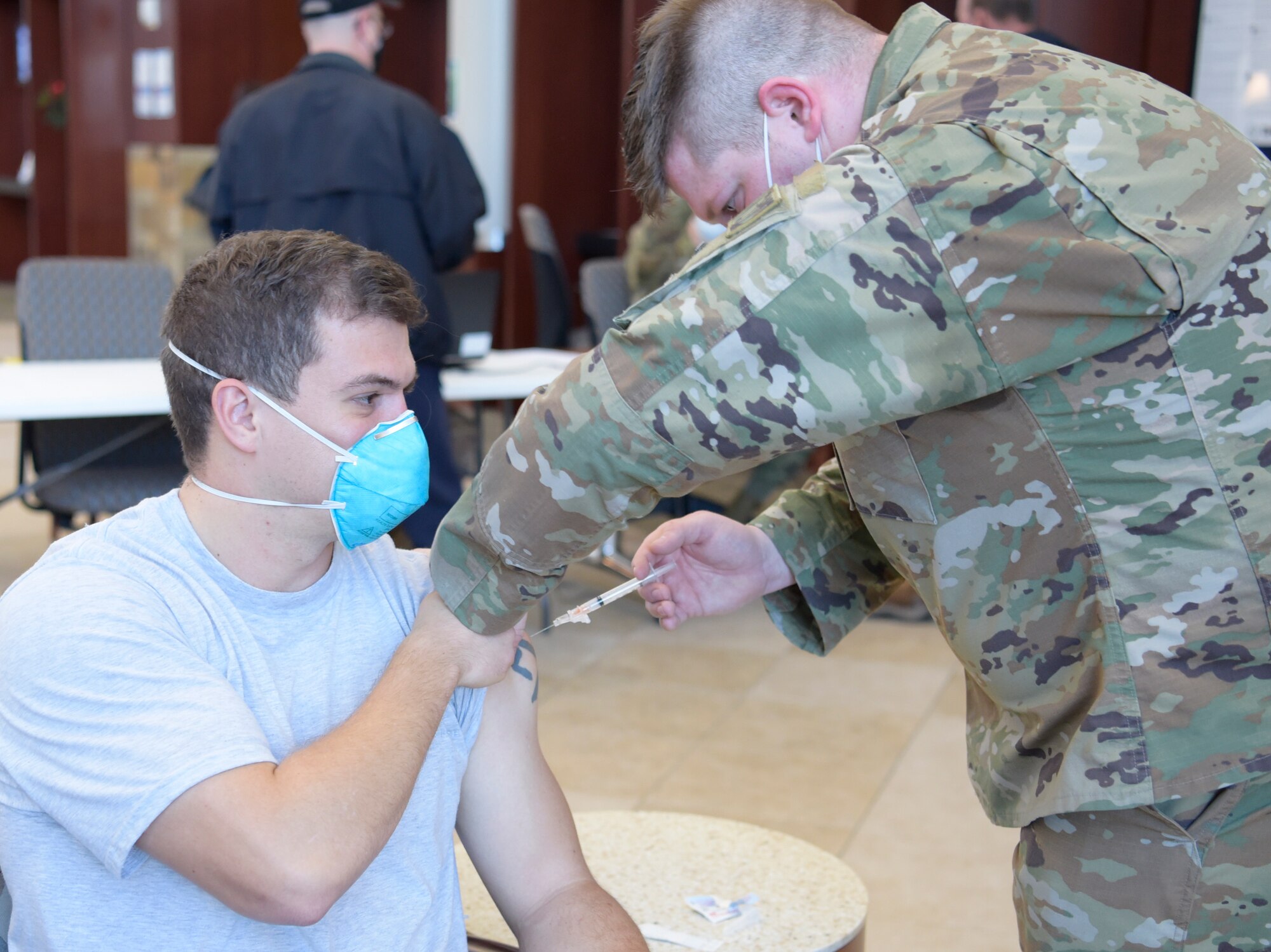 Man gets vaccination from a man in military uniform