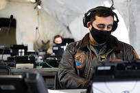 U.S. Navy Lt. Cmdr. Vince Gomes, assigned to Joint Task Force Civil Support, listens in on a teleconference from a command post tent as part of an equipment check in preparation for the command’s upcoming exercise Sudden Response 21.