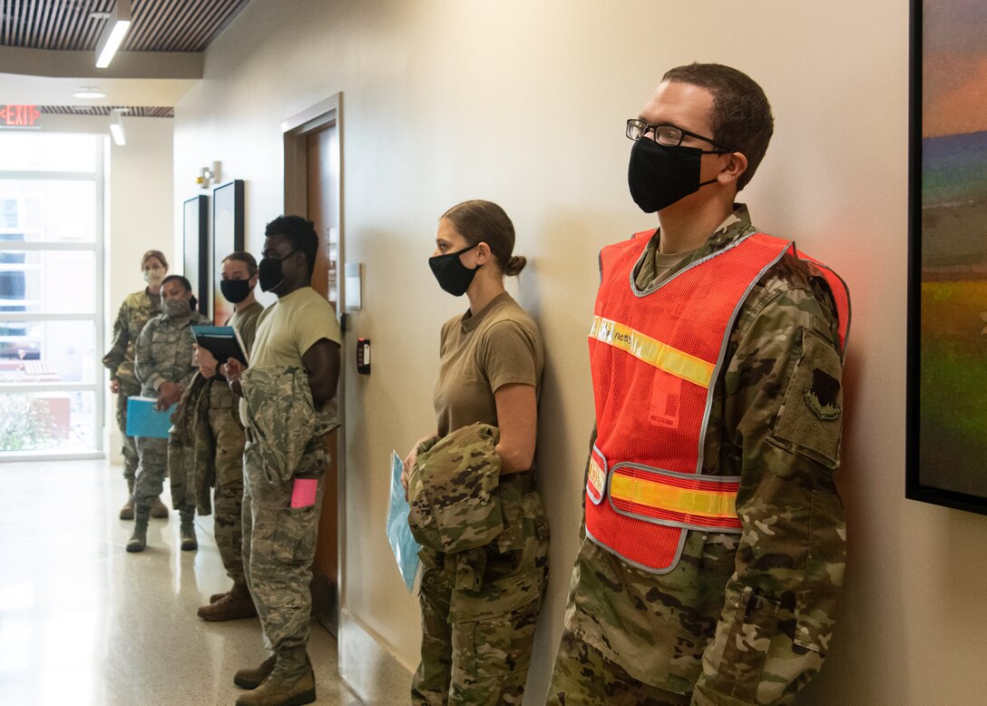 Airmen stand inside the 20th Medical Group in line for a vaccine.