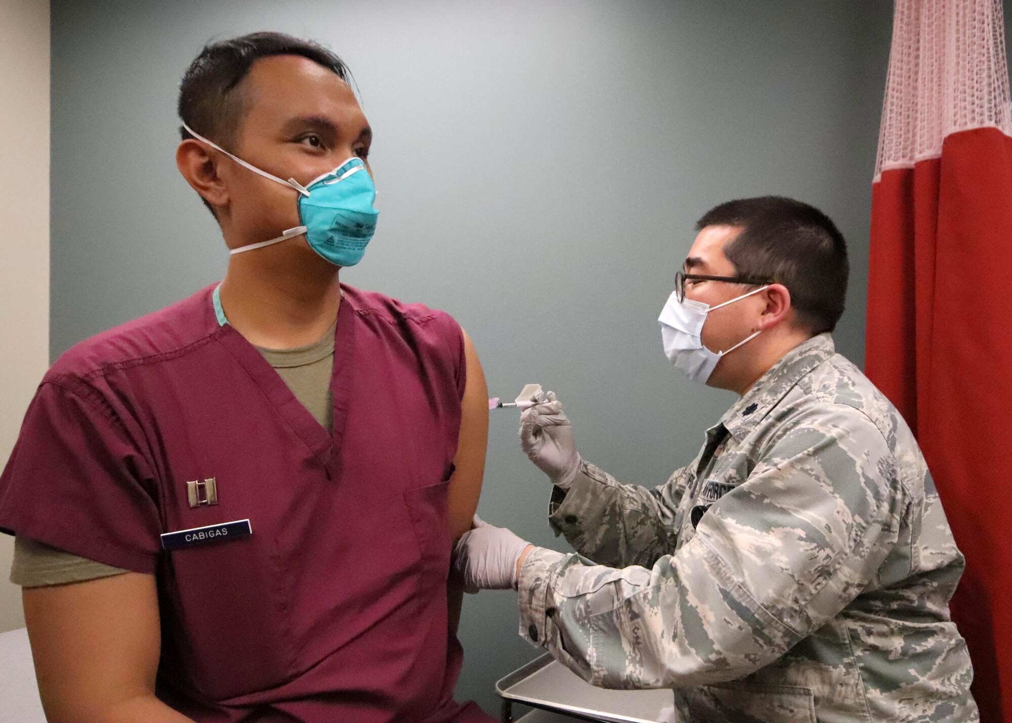 U.S. Air Force Lt. Col. Edward Champoux, the 673d Health Care Operations Squadron Allergy and Immunization Clinic chief and Pacific Air Forces regional allergist, administers the first of a two-dose series of a COVID-19 vaccine to U.S. Air Force Capt. Orlando Cabigas, a clinical nurse with the 673d Health Care Operations Squadron Emergency Services Flight, at Joint Base Elmendorf-Richardson, Alaska, Dec. 30, 2020. Upon receiving the initial shipment of the vaccine, JBER began inoculating personnel following the Centers for Disease Control and Prevention’s prioritization guidelines. The vaccine is part of Operation Warp Speed, a national initiative to accelerate the development, production and distribution of safe and effective COVID-19 vaccines, therapeutics and diagnostics.