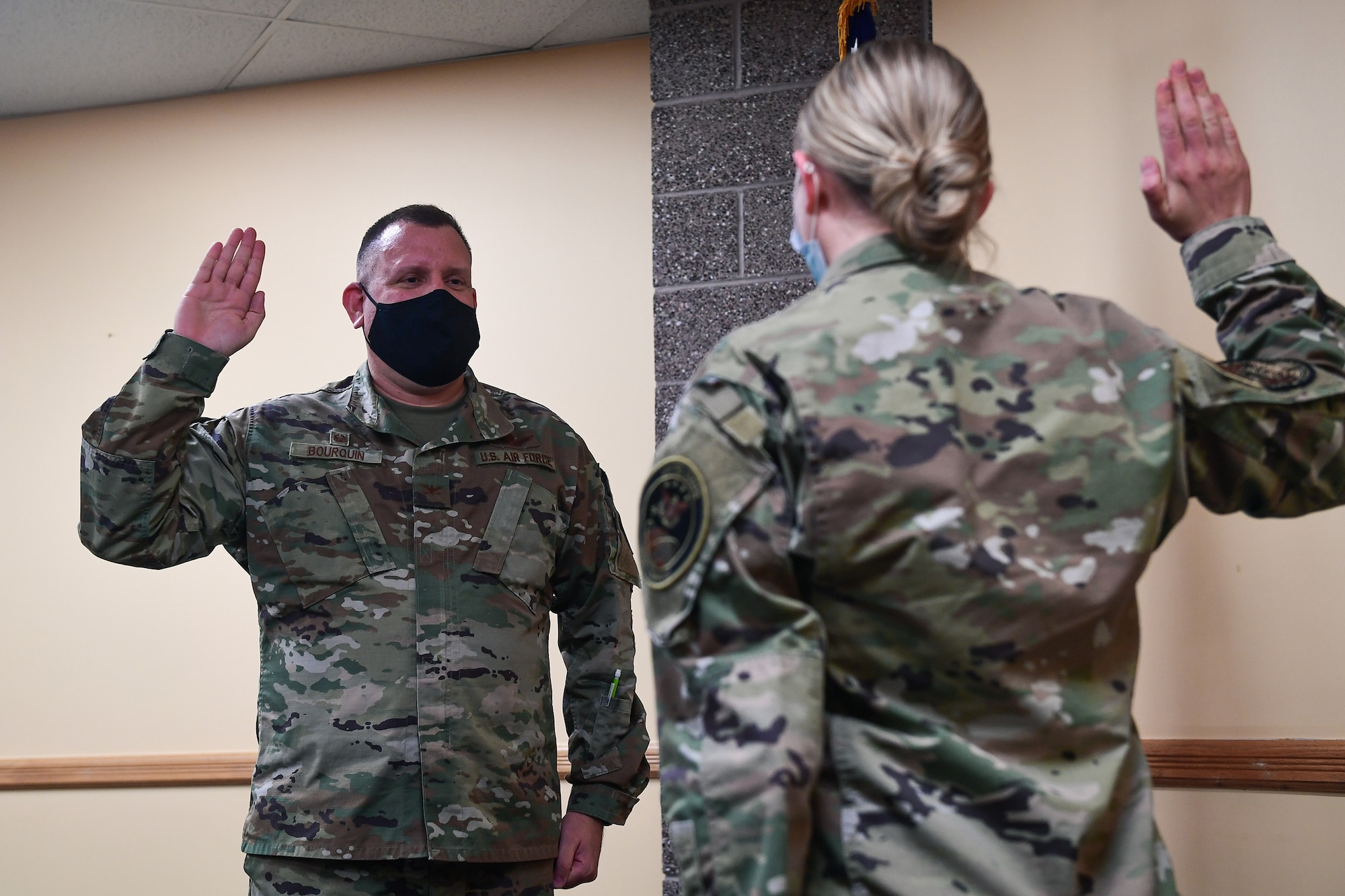 Col. Richard Bourquin (left), Space Delta 4 commander, is commissioned into the U.S. Space Force by 1st Lt. Sydney Hauver (right), 11th Space Warning Squadron executive officer,  during a small ceremony at Buckley Air Force Base, Colo., Jan. 5, 2021.