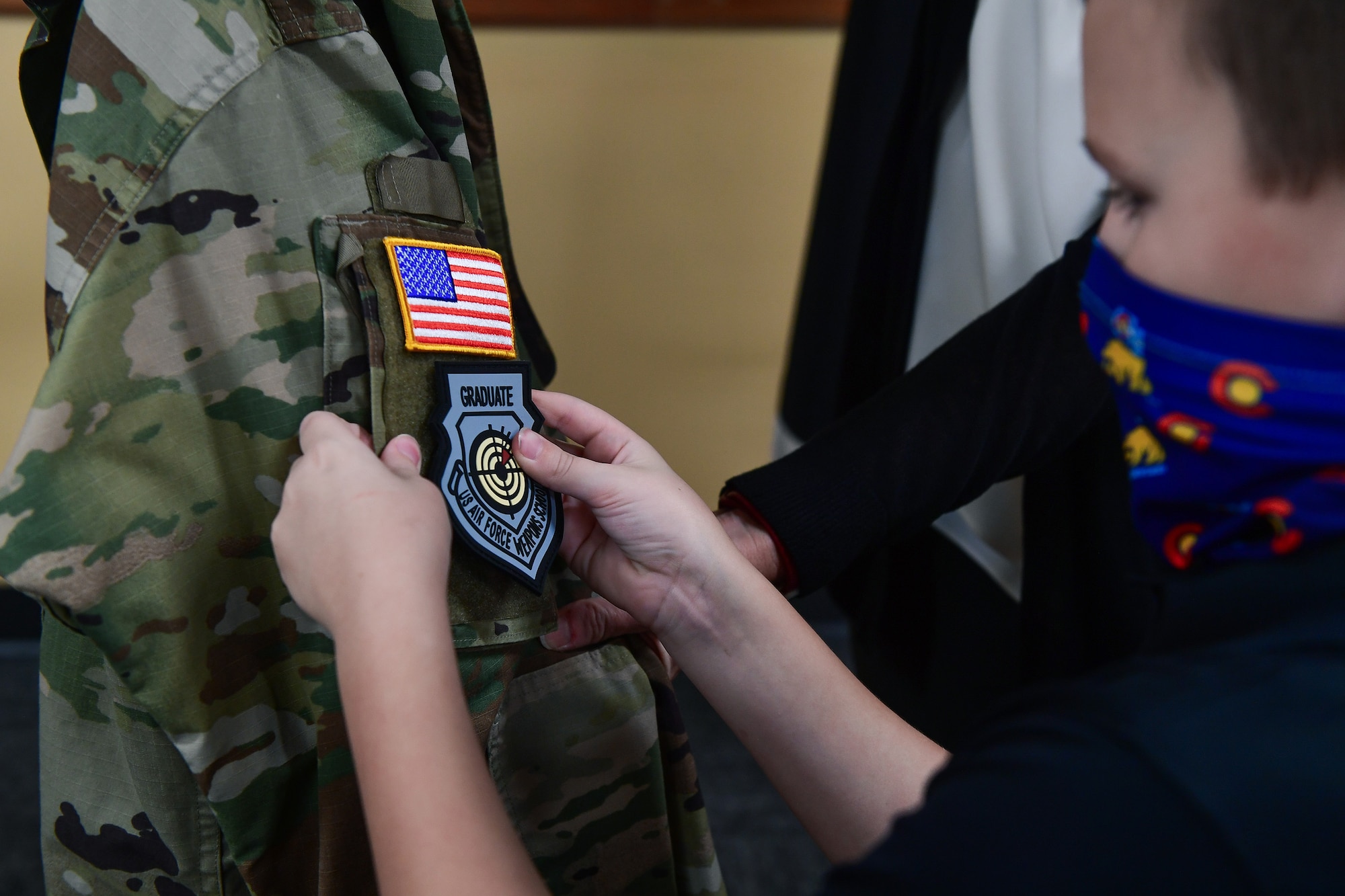Col. Richard Bourquin, Space Delta 4 commander, has his U.S. Air Force Weapons School Graduate patch placed onto his Space Force uniform by his son, Bennett Bourquin, in the DEL 4 conference room at Buckley Air Force Base, Colo., Jan 5, 2021.