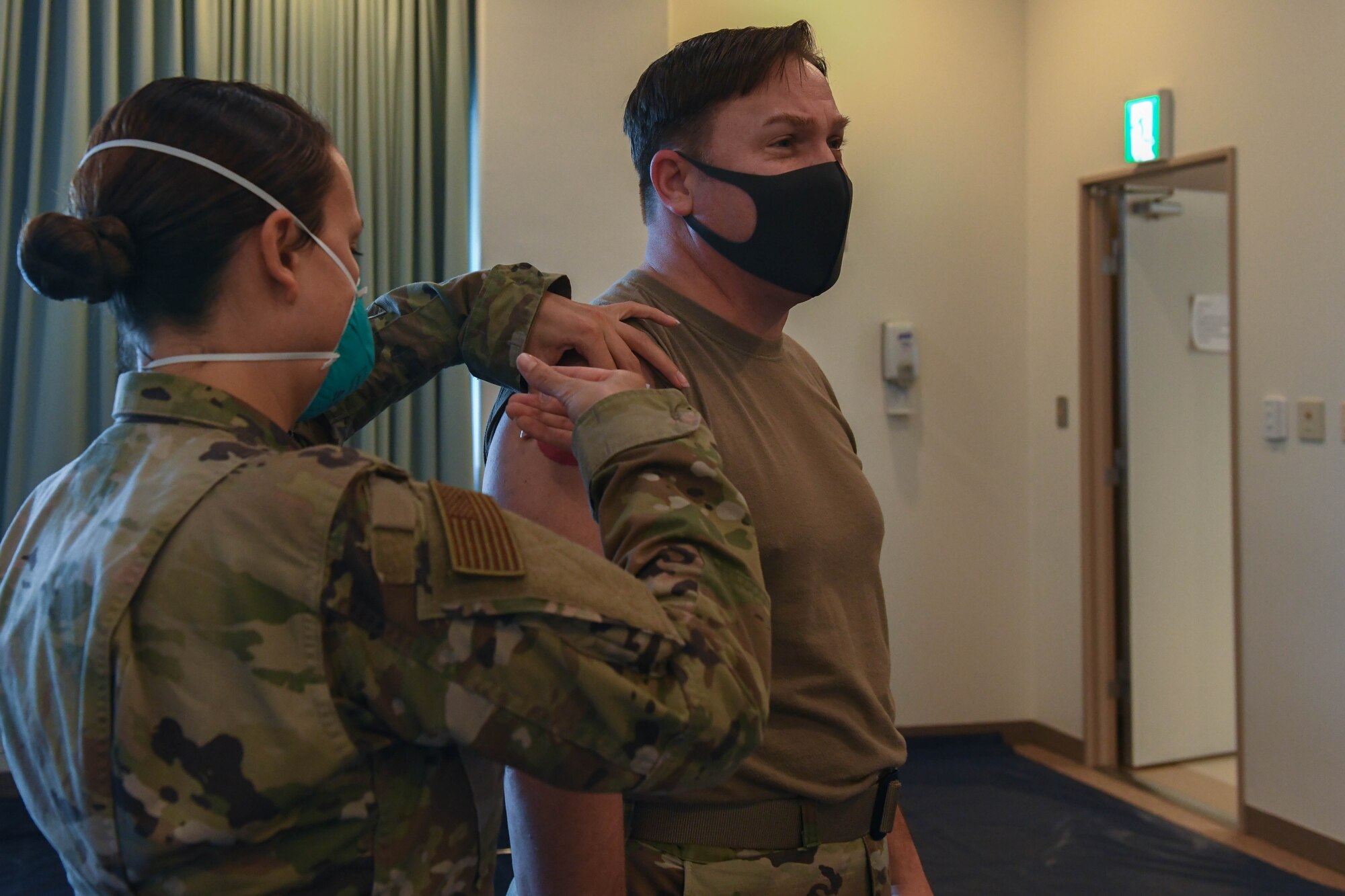 U.S. Air Force Tech. Sgt. Christina Reynoso, the NCO in charge of the immunizations clinic with the 18th Healthcare Operations Squadron, administers the Moderna’s vaccine to Col. Jay Veeder, commander of the 18th Medical Group at Kadena Air Base, Japan, Dec. 28, 2020. As part of DoD’s strategy for prioritizing, distributing and administering the COVID-19 vaccine, those providing direct medical care and emergency services will be prioritized to receive the vaccine at units based in Japan, including Kadena AB. (U.S. Air Force photo by Airman 1st Class Yosselin Perla)