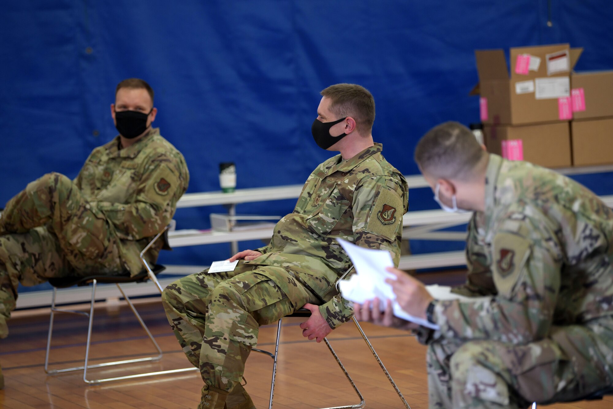 U.S. Air Force Capt. Joshua Craig (left), Tech. Sgt. Nathan Wehrle (middle) and Staff Sgt. Bryan Cooper (right) from the 18th Aeromedical Evacuation Squadron sit patiently waiting through the observation period after receiving the Moderna COVID-19 Vaccine, Jan. 4, 2021, at Kadena Air Base, Japan. As part of the DoD strategy for prioritizing, distributing and administering the COVID-19 vaccine, those providing direct medical care and emergency services will be prioritized to receive the vaccine at units based in Japan, including Kadena AB. (U.S. Air Force photo by Airman 1st Class Rebeckah Medeiros)