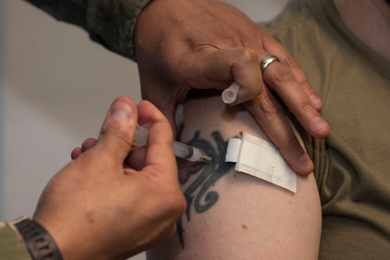 U.S. Air Force Senior Master Sgt. Shareef Cardwell, 52nd Medical Operations Squadron superintendent, administers a COVID-19 vaccine to Master Sgt. Fay Craigmile, 52nd Civil Engineer Squadron Fire and Emergency Services interim deputy fire chief, Jan. 4, 2021, at Spangdahlem Air Base, Germany. After receiving the COVID-19 vaccine, service members will continue adhering to Department of Defense and Centers for Disease Control and Prevention guidelines, such as consistently washing hands, wearing face masks and maintaining physical distancing. (U.S. Air Force photo by Senior Airman Melody W. Howley)