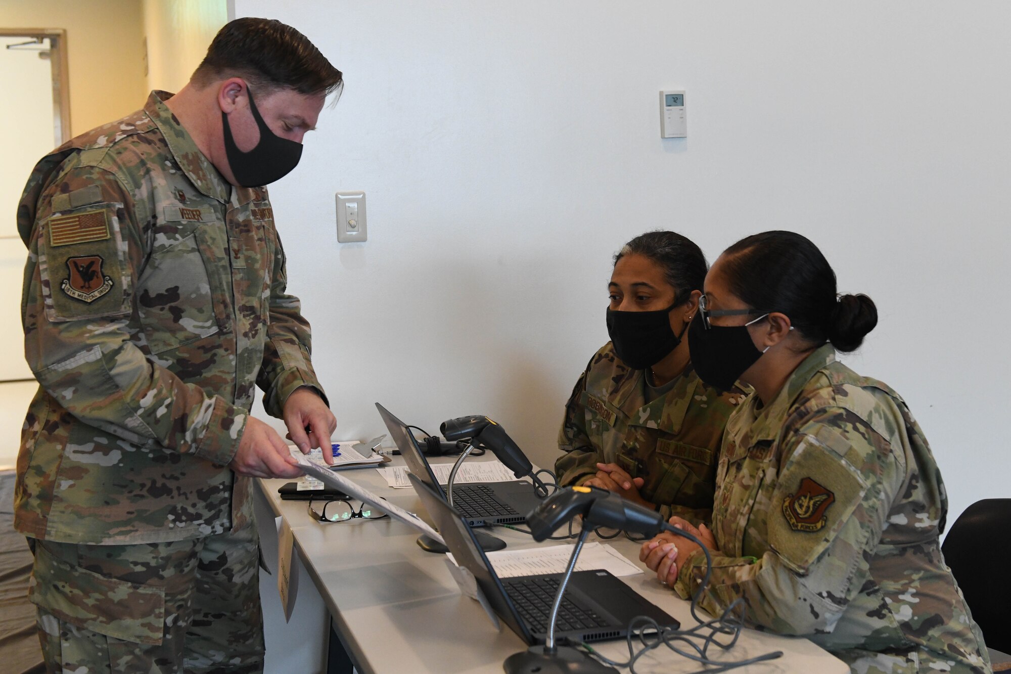 U.S. Air Force Col. Jay Veeder, commander of the 18th Medical Group, fills out a screening questionnaire prior to receiving the Moderna’s vaccine at Kadena Air Base, Japan, Dec. 28, 2020. As part of DoD’s strategy for prioritizing, distributing and administering the COVID-19 vaccine, those providing direct medical care and emergency services will be prioritized to receive the vaccine at units based in Japan, including Kadena AB. (U.S. Air Force photo by Airman 1st Class Yosselin Perla)