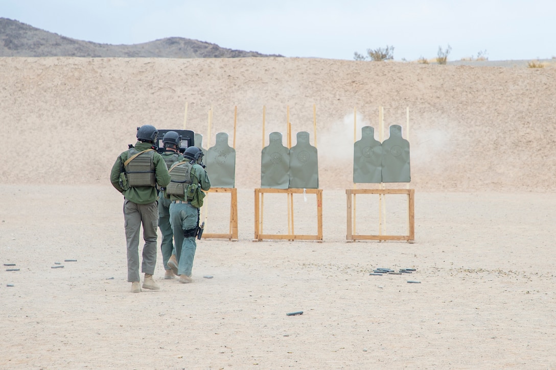 U.S. Marine Corps Sgt. Marcus Edwards, team commander, Special Reaction Team, Provost Marshall’s Office, Marine Air Ground Task Force Training Command, coaches his Marines on movement and breaching techniques during an SRT familiarization range at Marine Corps Air Ground Combat Center, Twentynine Palms, California, Dec. 11, 2020. SRT Marines are military police officers trained in hostage situation, active shooter and barricaded suspect response. (U.S. Marine Corps photo by Lance Cpl. Joshua Sechser)