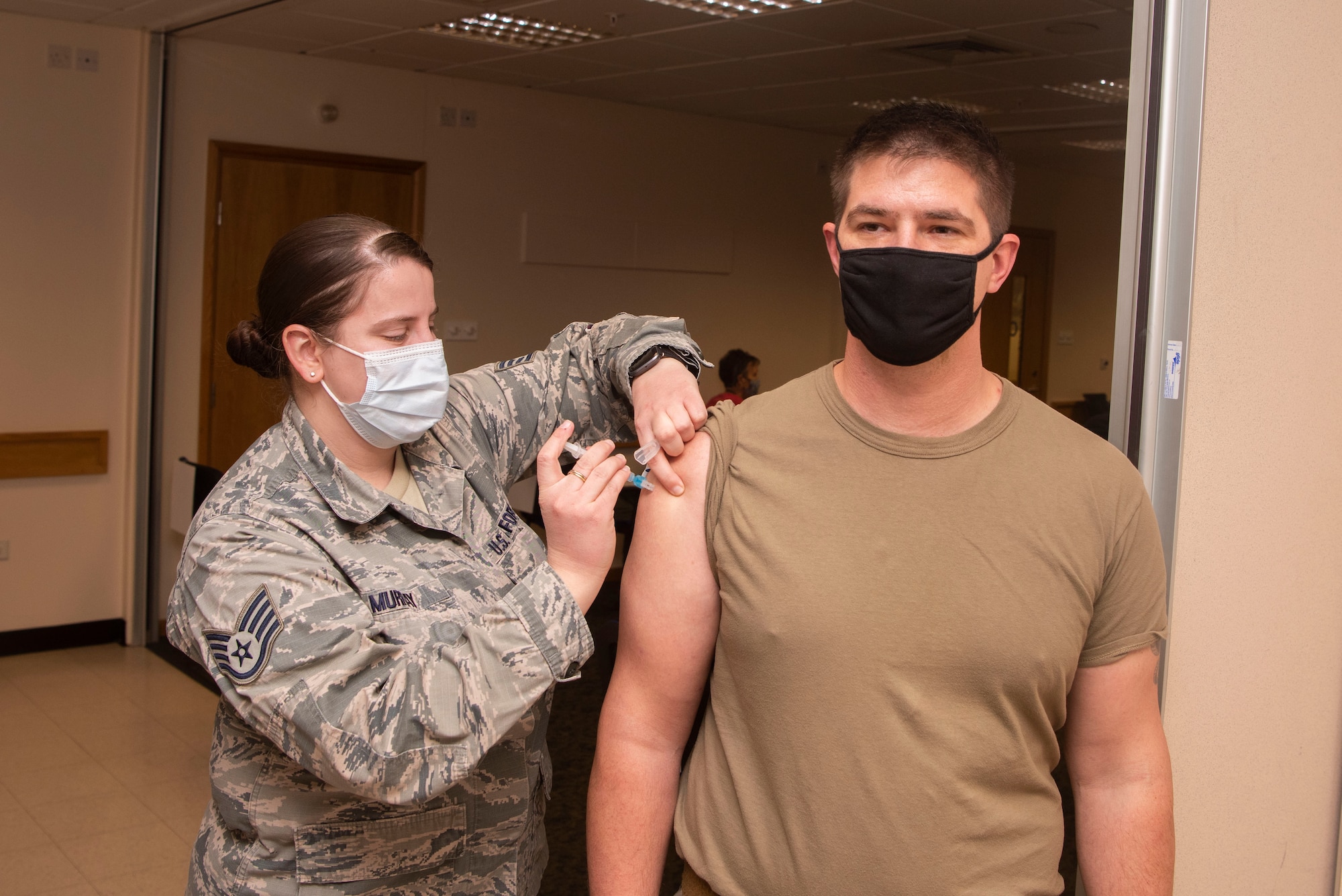 U.S. Air Force Staff Sgt. Anna Murray, 48th Healthcare Operations Squadron immunizations technician, administers a dose of the COVID-19 vaccine to a Team Mildenhall Airman Jan. 5, 2021, at Royal Air Force Lakenheath, England. Medical personnel, individuals maintaining national security and installation functions, deploying forces and those at high risk will be the first to receive the vaccine. (U.S. Air Force photo by Senior Airman Joseph Barron)