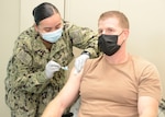 MANAMA, Bahrain (December 30, 2020) Capt. Greg Smith, Naval Support Activity (NSA) Bahrain’s commanding officer, receives the COVID-19 vaccine from Hospital Corpsman 2nd Class Rose Martinez. The vaccine is being administered in phases based on priority levels to reduce the burden of COVID-19 in high-risk populations and simultaneously mitigate risk to military operations. (U.S. Navy photo by Mass Communication Specialist 1st Class Justin Yarborough/Released)