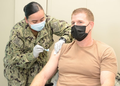 MANAMA, Bahrain (December 30, 2020) Capt. Greg Smith, Naval Support Activity (NSA) Bahrain’s commanding officer, receives the COVID-19 vaccine from Hospital Corpsman 2nd Class Rose Martinez. The vaccine is being administered in phases based on priority levels to reduce the burden of COVID-19 in high-risk populations and simultaneously mitigate risk to military operations. (U.S. Navy photo by Mass Communication Specialist 1st Class Justin Yarborough/Released)