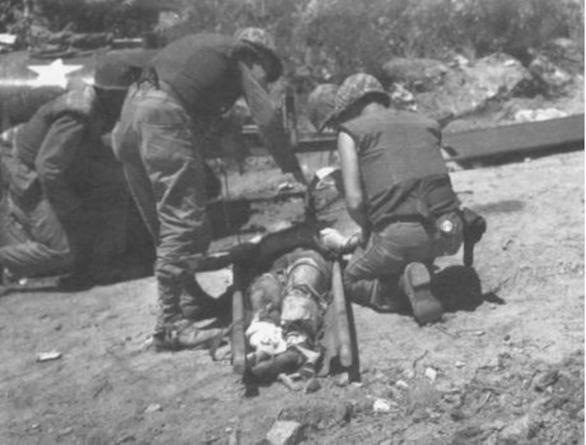 Four men tend to an injured man on a stretcher.