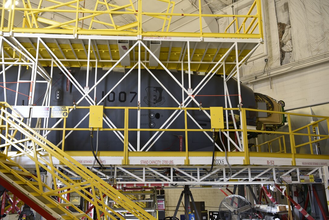 Photo of aircraft in hangar with scaffolding around it.