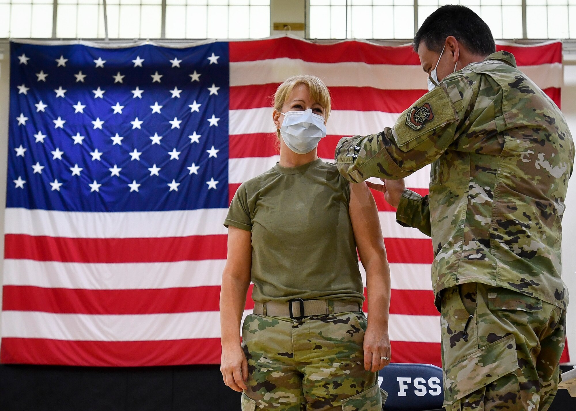 Airman administers vaccine shot to a service member.