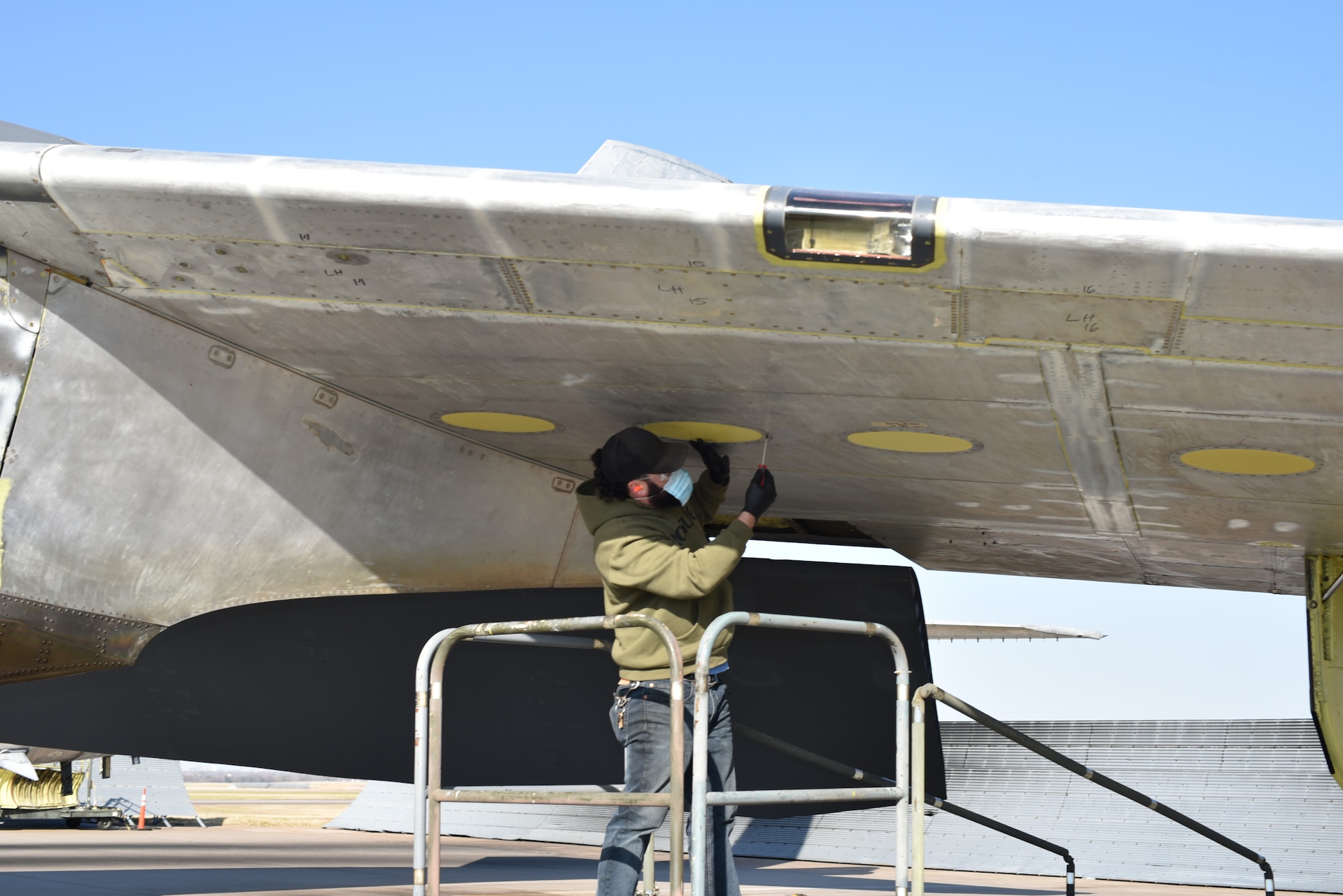 Man working on wing of airplane.