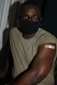 Spc. Selebika Saniyo poses for a photograph after receiving the first of two COVID-19 vaccinations at Camp Johnson, Vermont, Jan. 6, 2021. Saniyo, an automated logistics specialist with the 158th Brigade Support Battalion, said he volunteered to receive the shot because he wants to gain immunity from COVID-19 and trusts the Vermont National Guard's medical personnel. The second dose of the Moderna COVID-19 vaccine is administered four weeks after the first shot, and a person gains effective immunity three to four weeks after the second shot.