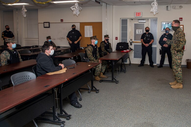 U.S. Marine Corps Lt. Col. Matthew Dowden, right, commanding officer of 2nd Tank Battalion, 2nd Marine Division, gives a speech after presenting the Lifesaving Award to Michael Walusz and Adam Wallace, both police officers with the Marine Corps Base Camp Lejeune Provost Marshal’s Office (PMO), at PMO on MCB Camp Lejeune, North Carolina, Dec. 16, 2020. The police officers received the award for their life-saving actions following an accident in which a Marine with 2nd Tank Battalion was severely injured. (U.S. Marine Corps photo by Lance Cpl. Christian Ayers)