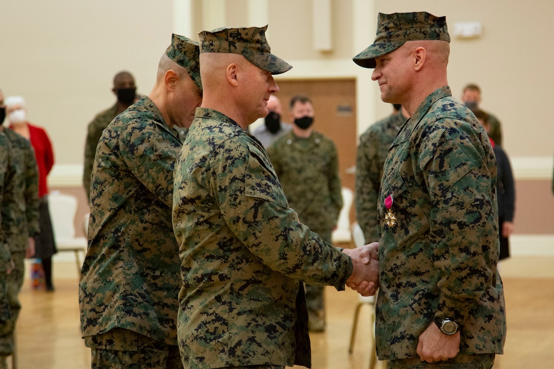 U.S. Marine Corps Maj. Gen Julian D. Alford, left, commanding general, Marine Corps Installations East-Marine Corps Base Camp Lejeune, awards Sgt. Maj. Charles A. Metzger, right, outgoing sergeant major for MCIEAST-MCB Camp Lejeune, the Legion of Merit during a relief and appointment ceremony at Marston Pavilion on MCB Camp Lejeune, North Carolina, Dec. 21, 2020. Metzger, outgoing sergeant major for MCIEAST-MCB Camp Lejeune, relinquished his duties to Tellez and retired after 30 years of honorable service to the Marine Corps. (U.S. Marine Corps photo by Cpl. Ginnie Lee)
