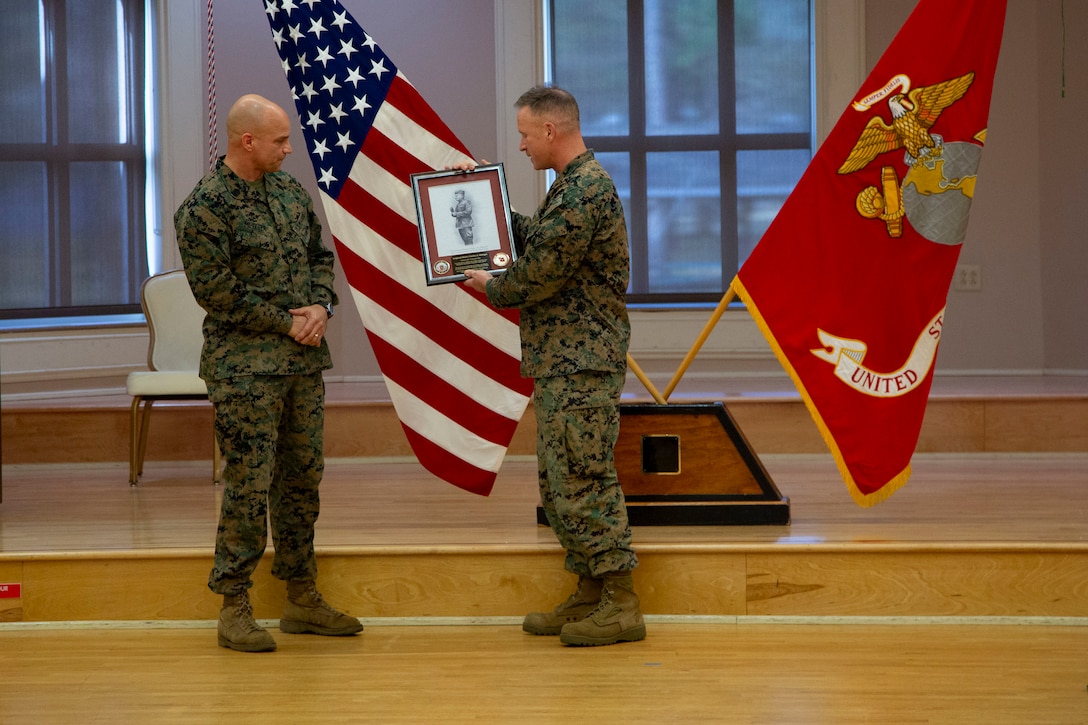 U.S. Marine Corps Col. Todd W. Ferry, right, deputy commander, Marine Corps Installations East- Marine Corps Base Camp Lejeune, presents Sgt. Maj. Charles A. Metzger, left, outgoing sergeant major for MCIEAST-MCB Camp Lejeune, a parting gift from the staff during a relief and appointment ceremony at Marston Pavilion on MCB Camp Lejeune, North Carolina, Dec. 21, 2020. Metzger, relinquished his duties to Sgt. Maj. Robert M. Tellez and retired after 30 years of honorable service to the Marine Corps. (U.S. Marine Corps photo by Cpl. Ginnie Lee)