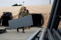 JOINT BASE LANGLEY-EUSTIS, Va. (January 6, 2021) U.S. Army Maj. Gwendolyn Bamford, assigned to Joint Task Force Civil Support’s J5 department, carries a table out of a command post tent at the conclusion of an equipment check in preparation for the command’s upcoming exercise Sudden Response 21.