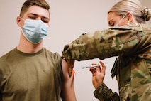 Airman 1st Class James Gehne, 375th Civil Engineer Squadron firefighter, receives the first COVID-19 inoculation on Scott Air Force Base, Ill., Jan 6, 2021. Vaccines combating COVID-19 use inactivated virus genetics to strengthen the immunity properties of the receiver while still making it impossible to contract COVID-19 from the inoculation. (U.S. Air Force photo by Tech. Sgt. Jordan Castelan)