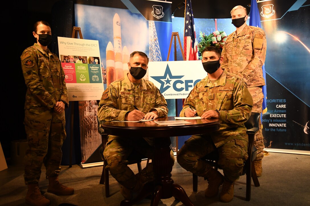 Col. Anthony Mastalir, 30th Space Wing commander, and Chief Master Sgt. Jason DeLucy, 30th SW command chief, sign the proclamation to kick-off the Combined Federal Campaign Dec. 11, 2020, at Vandenberg Air Force Base, Calif.