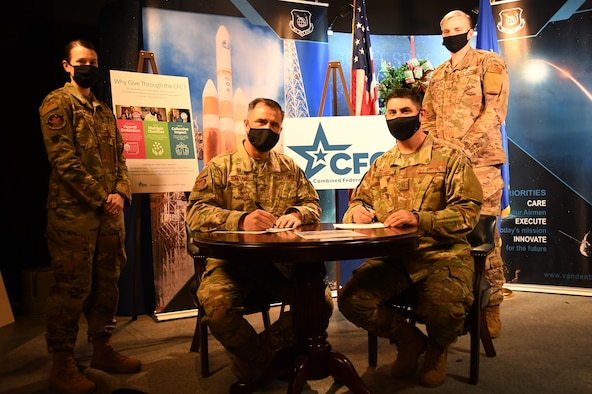 Col. Anthony Mastalir, 30th Space Wing commander, and Chief Master Sgt. Jason DeLucy, 30th SW command chief, sign the proclamation to kick-off the Combined Federal Campaign Dec. 11, 2020, at Vandenberg Air Force Base, Calif.