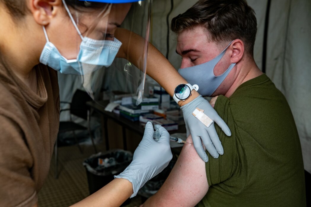 U.S. Marines and sailors with III Marine Expeditionary Force receive COVID-19 vaccines on Camp Foster, Okinawa, Japan, Dec. 29, 2020. Immediate vaccination administration prioritization will focus on those providing direct medical care and emergency services. Marine Forces Japan will use DoD’s phased approach to vaccinate all Active component, Reserve component, TRICARE Prime and TRICARE Select beneficiaries, and select DoD civilians and contract personnel authorized to receive immunizations from DoD, to remain a lethal and ready expeditionary fighting force. (U.S. Marine Corps photo by Lance Cpl. Natalie Greenwood)