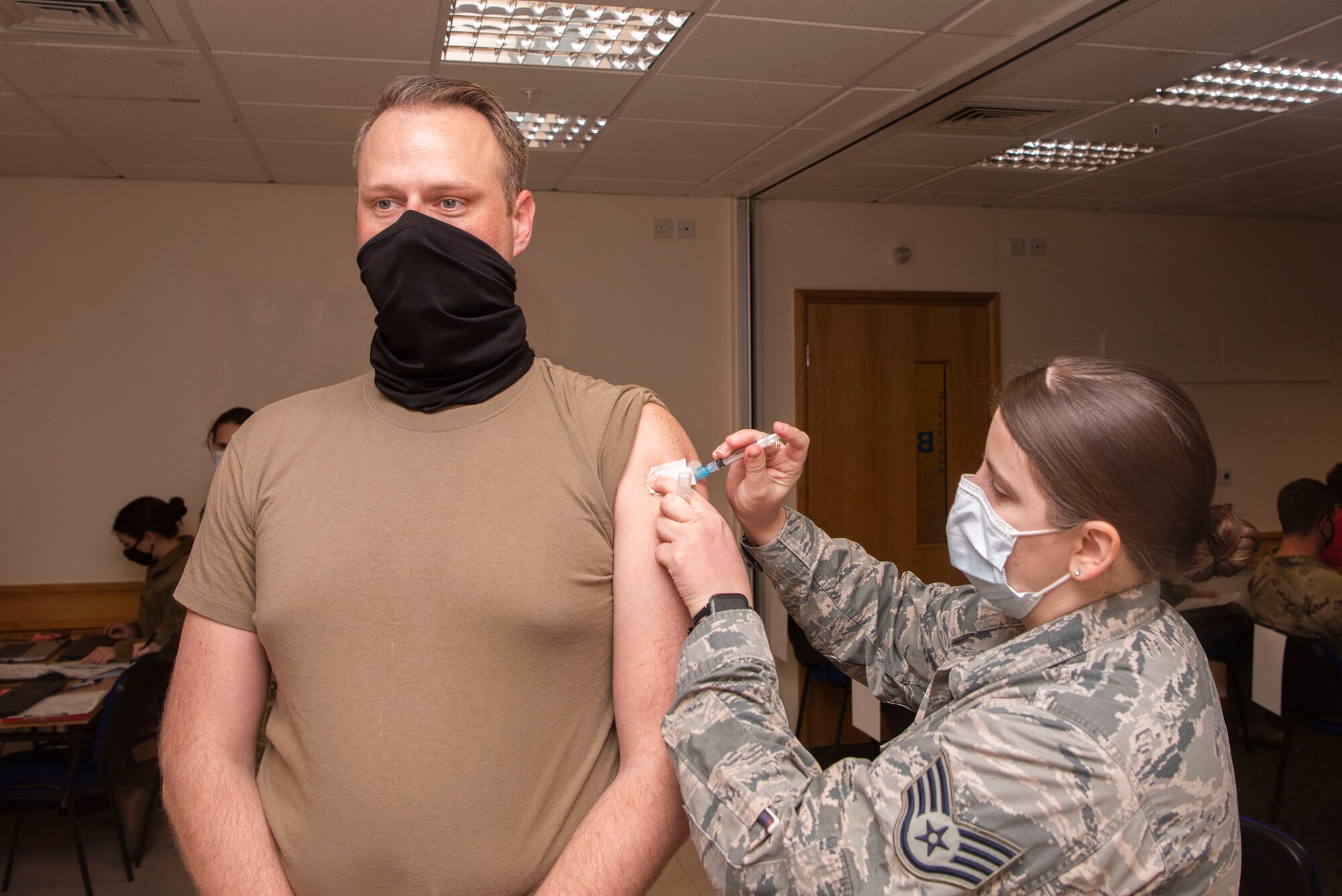 U.S. Air Force Staff Sgt. Anna Murray, 48th Healthcare Operations Squadron immunizations technician, administers a dose of the COVID-19 vaccine to a Team Mildenhall Airman Jan. 5, 2021, at Royal Air Force Lakenheath, England. Medical personnel, individuals maintaining national security and installation functions, deploying forces and those at high risk will be the first to receive the vaccine. (U.S. Air Force photo by Senior Airman Joseph Barron)