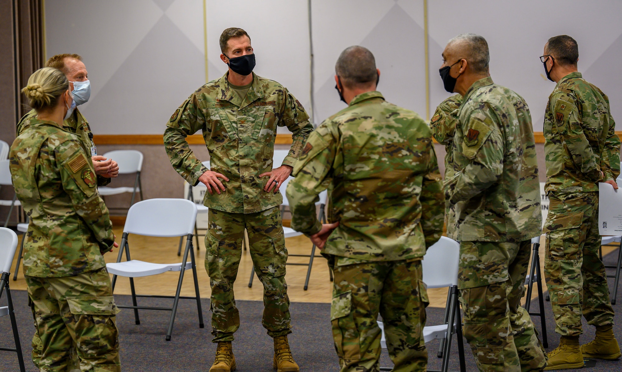 Airmen stand and talk in a circle.