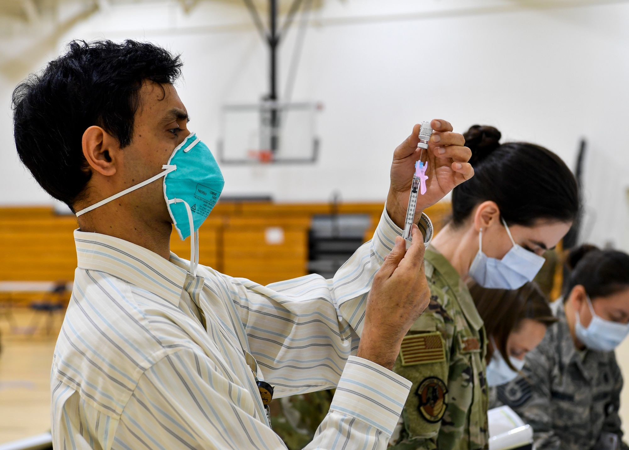 87th Medical Group personnel prepare syringes containing the COVID-19 vaccine at the Point of Dispensing on Joint Base McGuire-Dix-Lakehurst, New Jersey, Dec. 31, 2020. After receiving the initial vaccination, members will require a second dose to be considered vaccinated. (U.S. Air Force photo by Staff Sgt. Jake Carter)