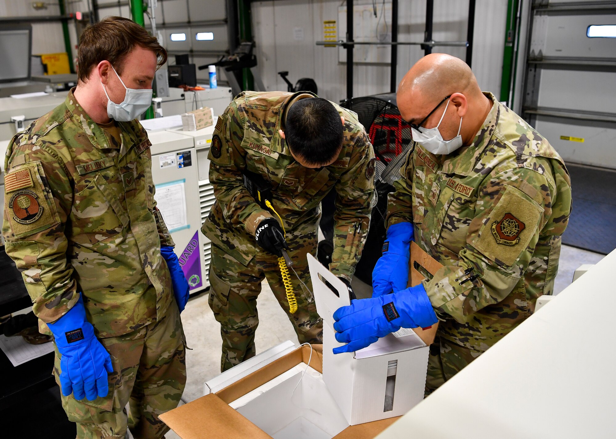 87th Medical Group personnel unpack COVID-19 vaccinations after arriving at Joint Base McGuire-Dix-Lakehurst, New Jersey, Dec. 31, 2020. The vaccines, which must be temperature controlled, were placed into freezers before being sent to the McGuire Fitness Center for distribution. (U.S. Air Force photo by Staff Sgt. Jake Carter)