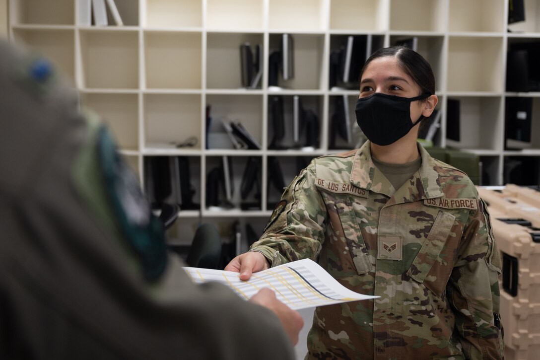 Senior Airman Krystal De Los Santos, 37th Bomb Squadron aviation resource management, hands a document to a U.S. Air Force B-1B Lancer pilot, at Andersen Air Force Base, Guam, in support of a Bomber Task Force mission, Dec. 23, 2020. Several B-1B aircraft deployed to Andersen AFB as part of U.S. Strategic Command’s support to the National Defense Strategy objectives of strategic predictability and operational unpredictability by using a mix of different aircraft to and from various dispersed U.S. bases and other departure and arrival points, to include Guam. (U.S. Air Force photo by Senior Airman Tristan Day)